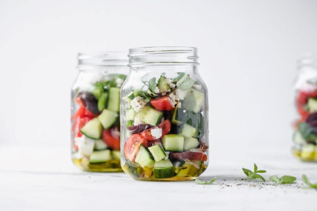 Greek salad in mason jars.
