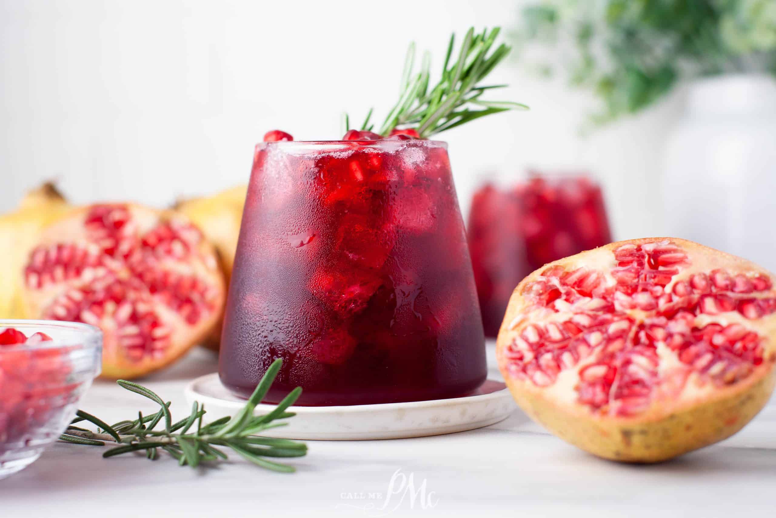 A refreshing cocktail made with pomegranate juice and garnished with rosemary sprigs.