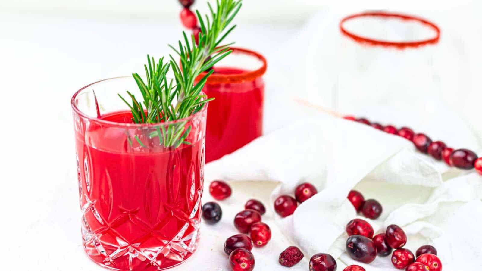 A glass of cranberry juice with a rosemary sprig.