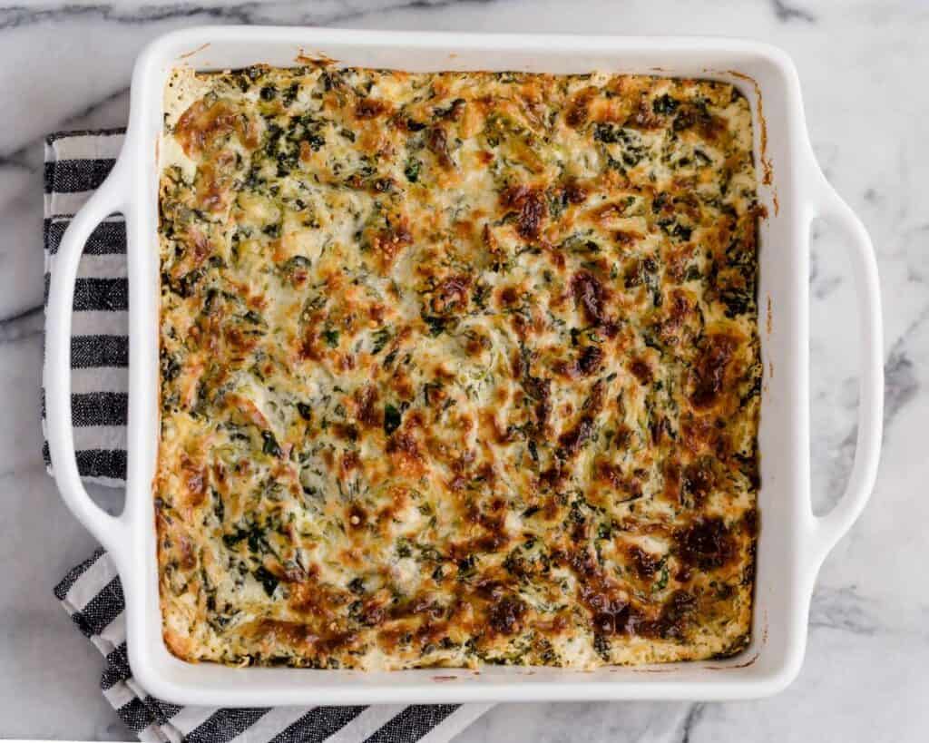 A dish with spinach and cheese in it.