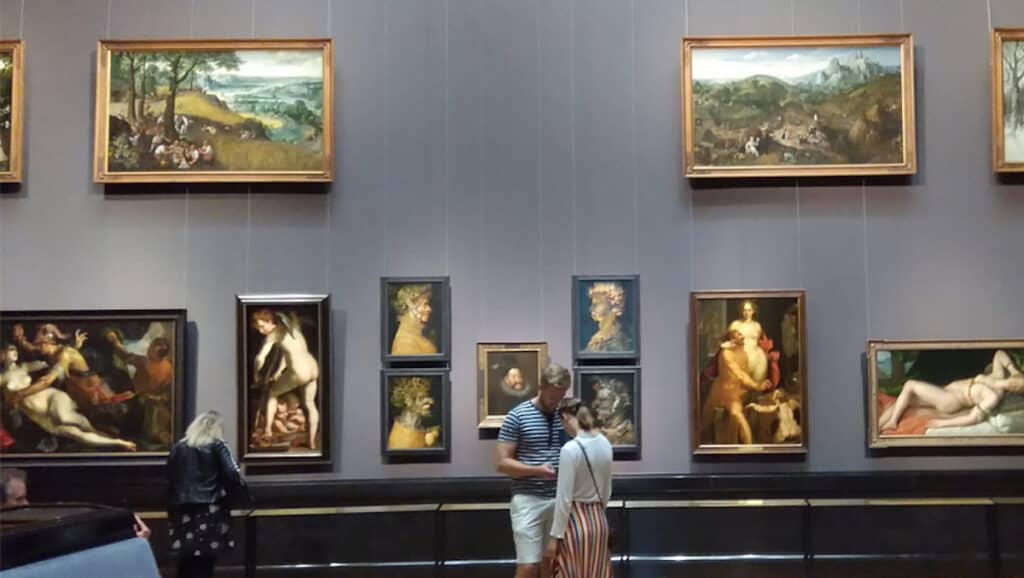 A group of people visiting a museum, admiring paintings.