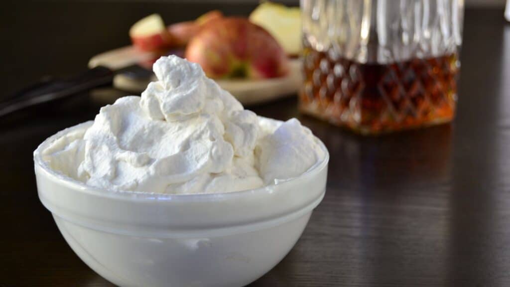 Maple bourbon whipped cream in a bowl on a table.