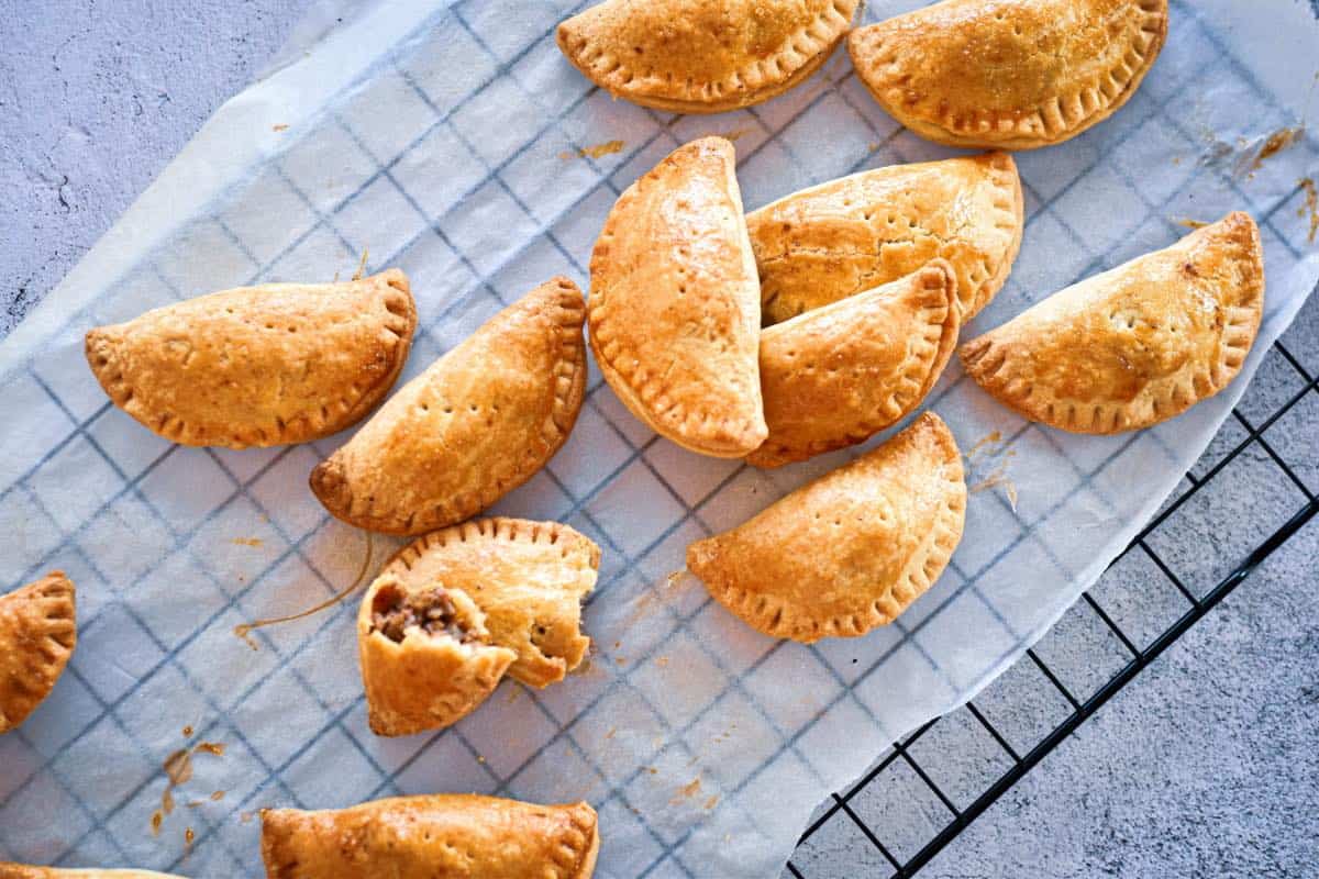 A tray of pasties on a cooling rack.