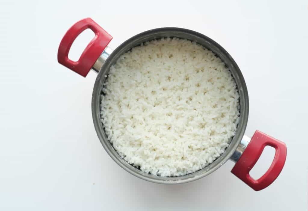 White rice in a pan on a white background.