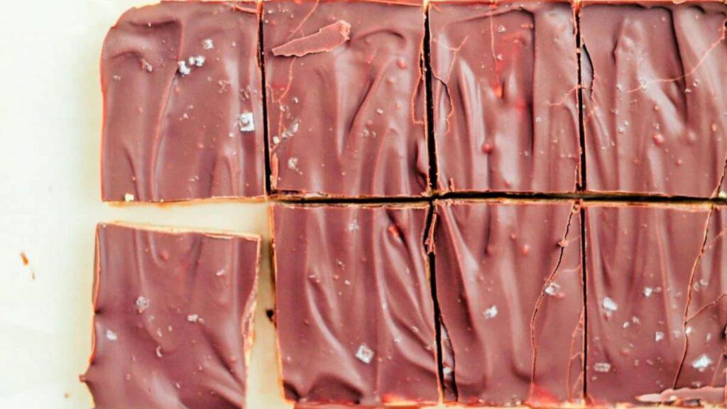 Chocolate bars cut into squares on a baking sheet.