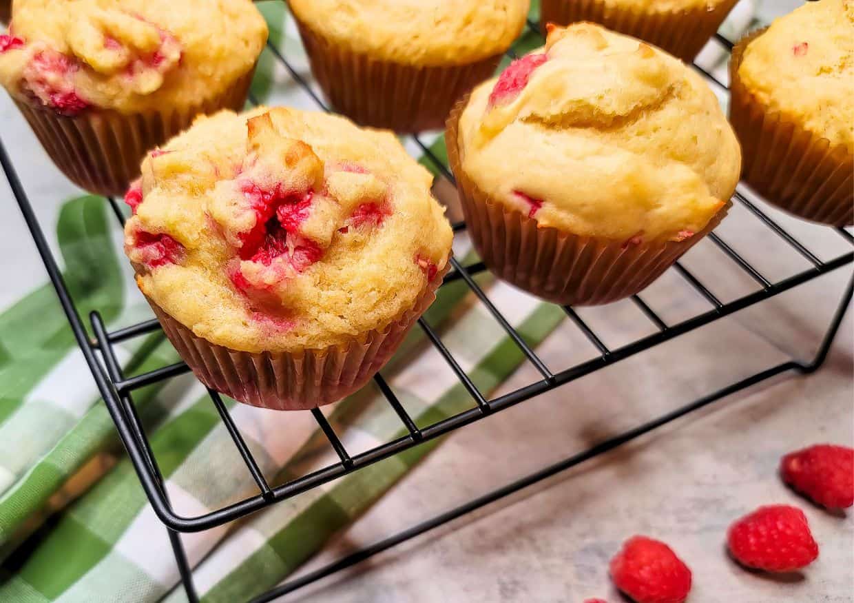 Raspberry muffins cooling on a wire rack.