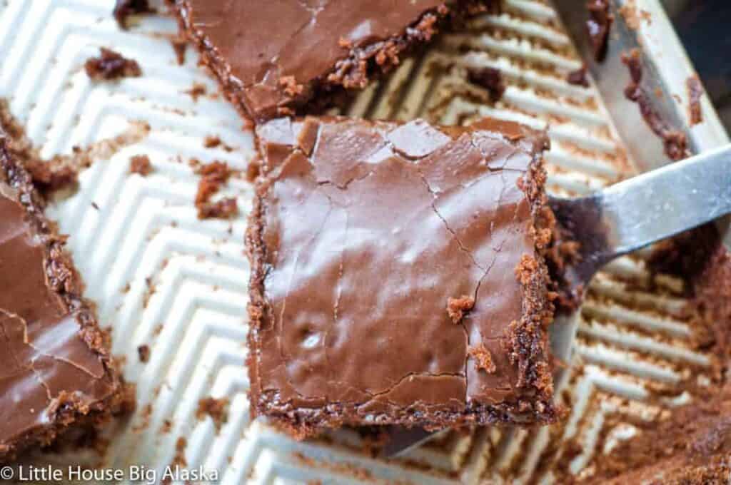 Chocolate brownies on a baking sheet with a fork.