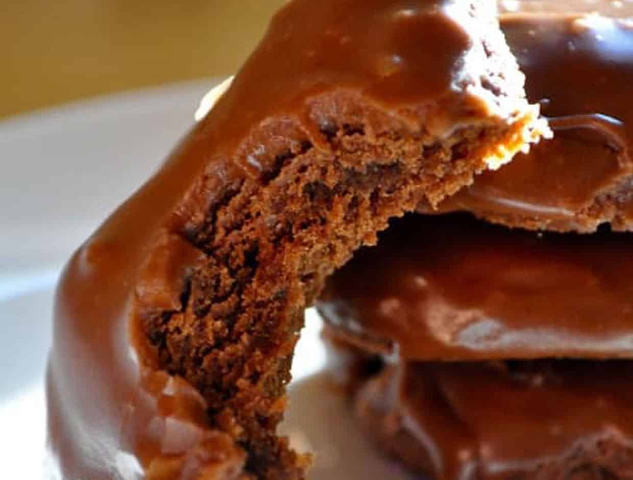 A stack of texas sheet cake cookies with a bite out of one cookie.