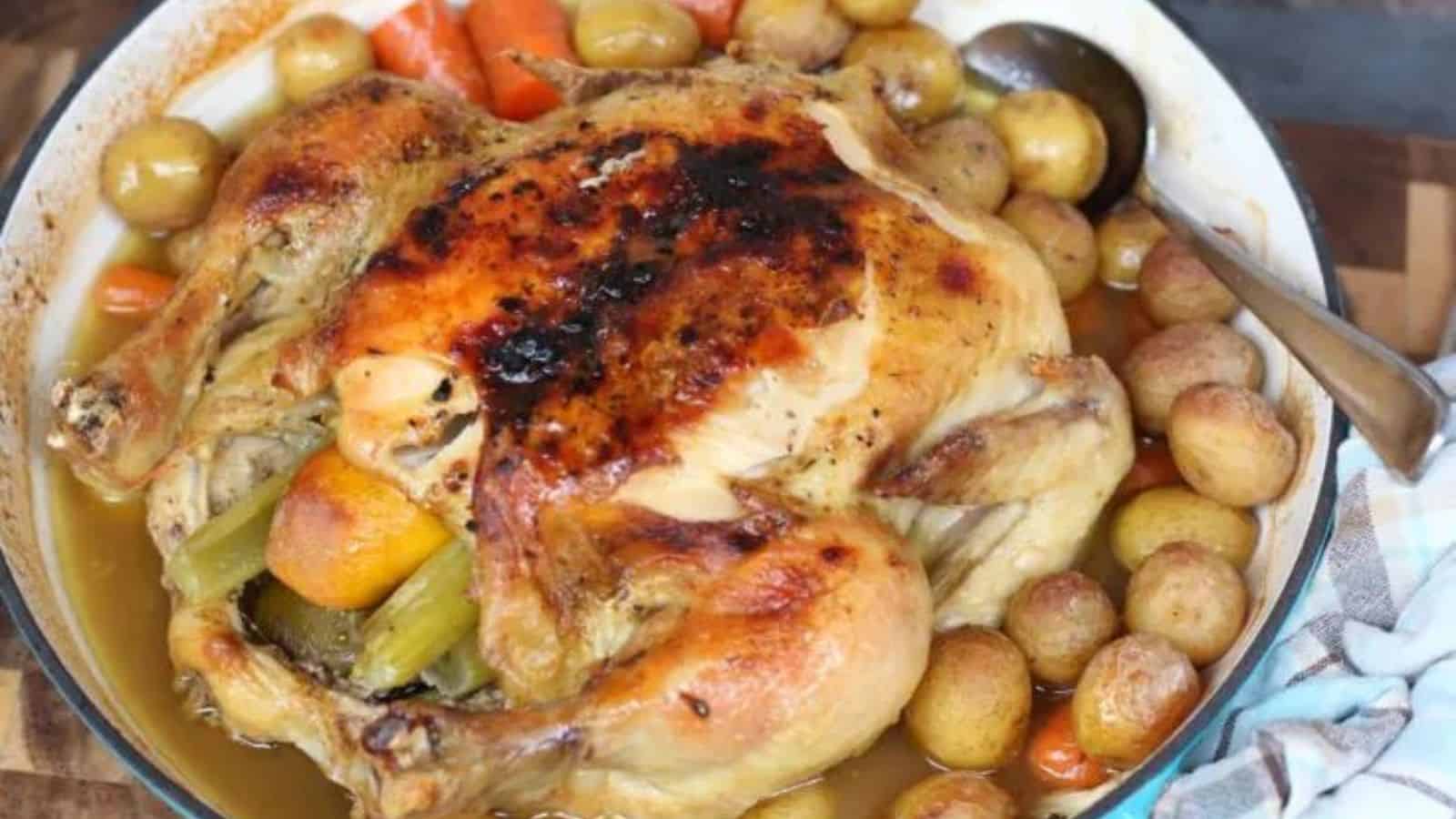 Roasted chicken and vegetables in a teal dish.