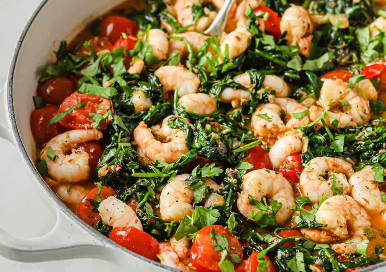 Tuscan garlic shrimp and spinach with tomatoes in a pan.