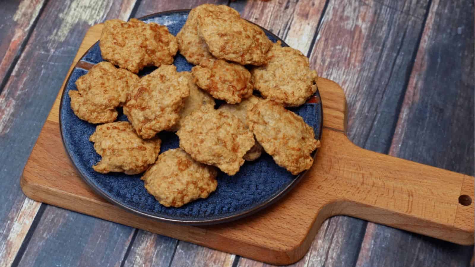 Plate of chicken nuggets on a wooden serving board.