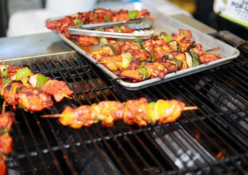 Chicken skewers being cooked on a grill.