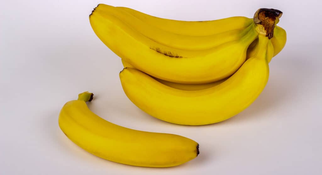 A bunch of bananas on a white surface.