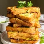 A stack of french toast topped with parsley.