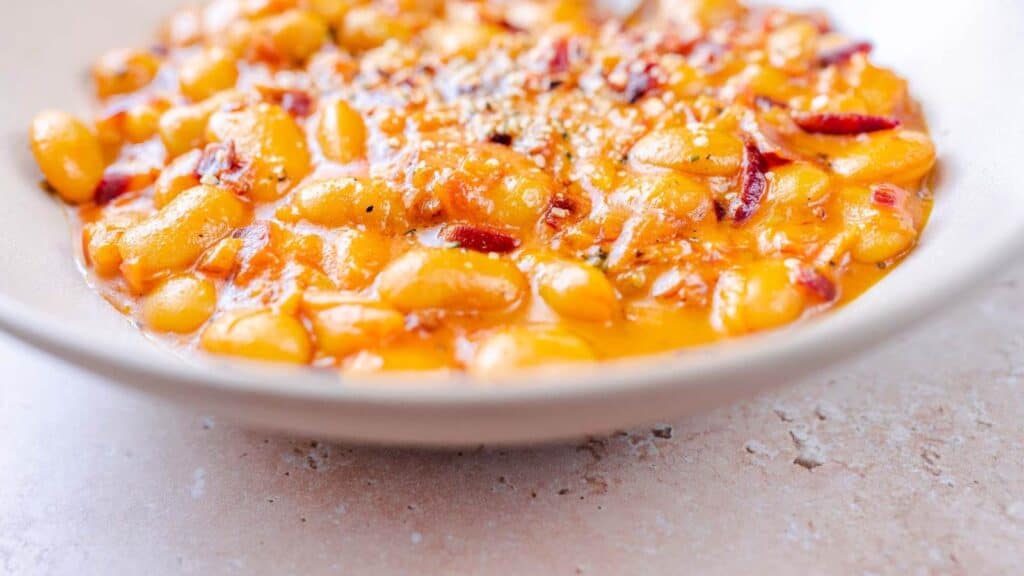 A bowl of beans in a bowl on a table.