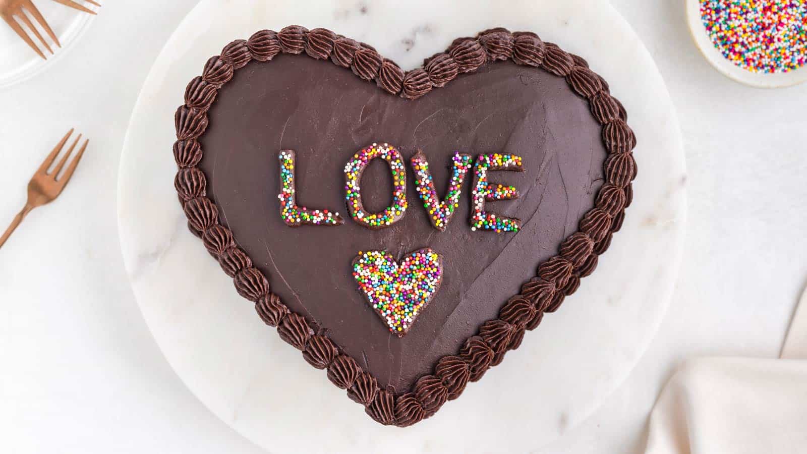 A chocolate cake in the shape of a heart with the word 