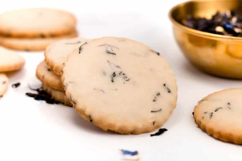 A bowl of cookies and a bowl of tea.