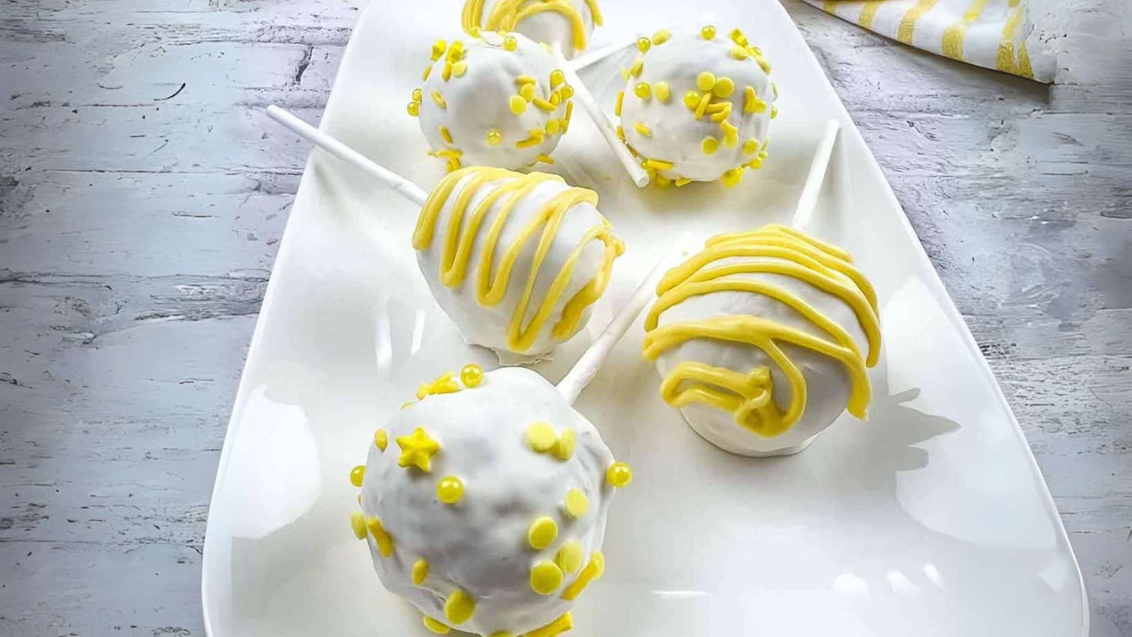 Lemon cake pops on a white plate.