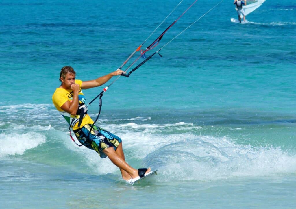 A man is kitesurfing in the ocean.