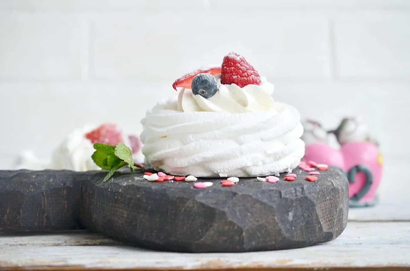 Side view of meringue cookie with berries.
