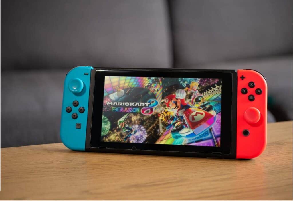 A nintendo switch, perfect for kids, is sitting on a table.