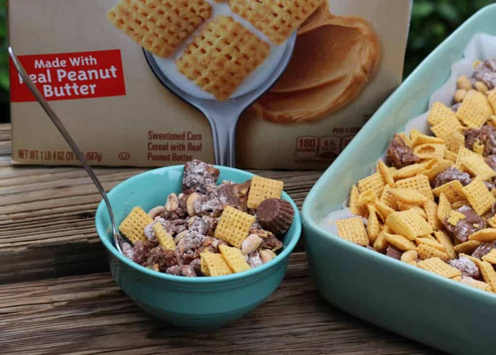 A bowl of cheesy granola with peanut butter next to a box of cheesy grano.