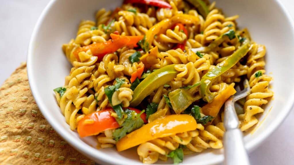 A bowl of pasta with vegetables and peppers.