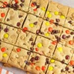 A square of chocolate chip cookie bars on a cutting board.