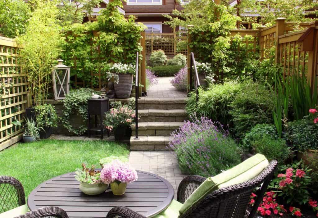 Garden design for a small backyard with a table and chairs.
