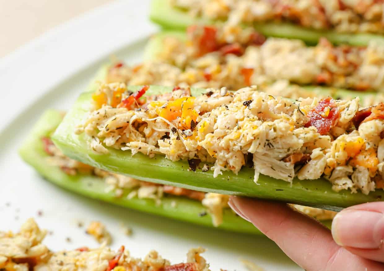 Bacon ranch chicken salad cucumber boats lined up on a plate.