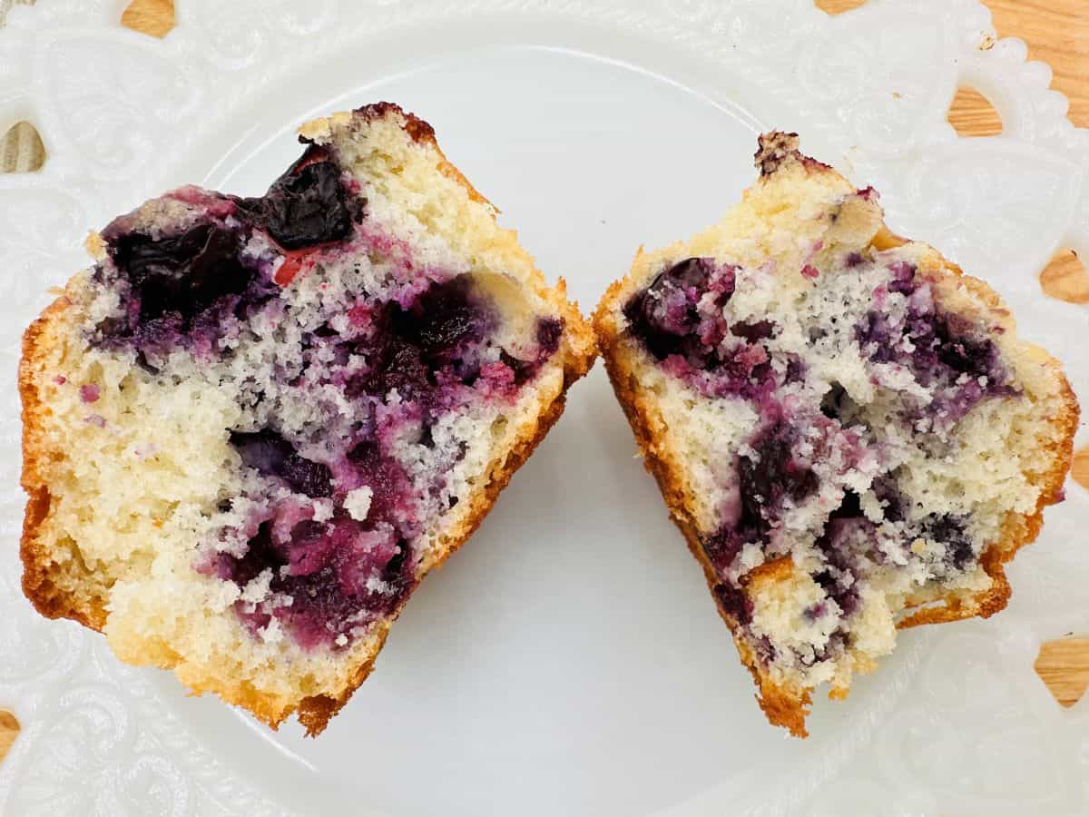 Two blueberry muffins on a white plate.