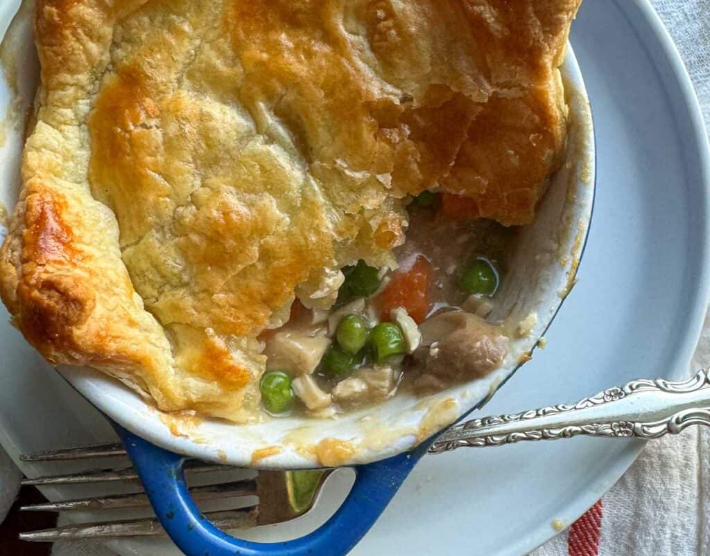 A homestyle pot pie served with a fork and knife.