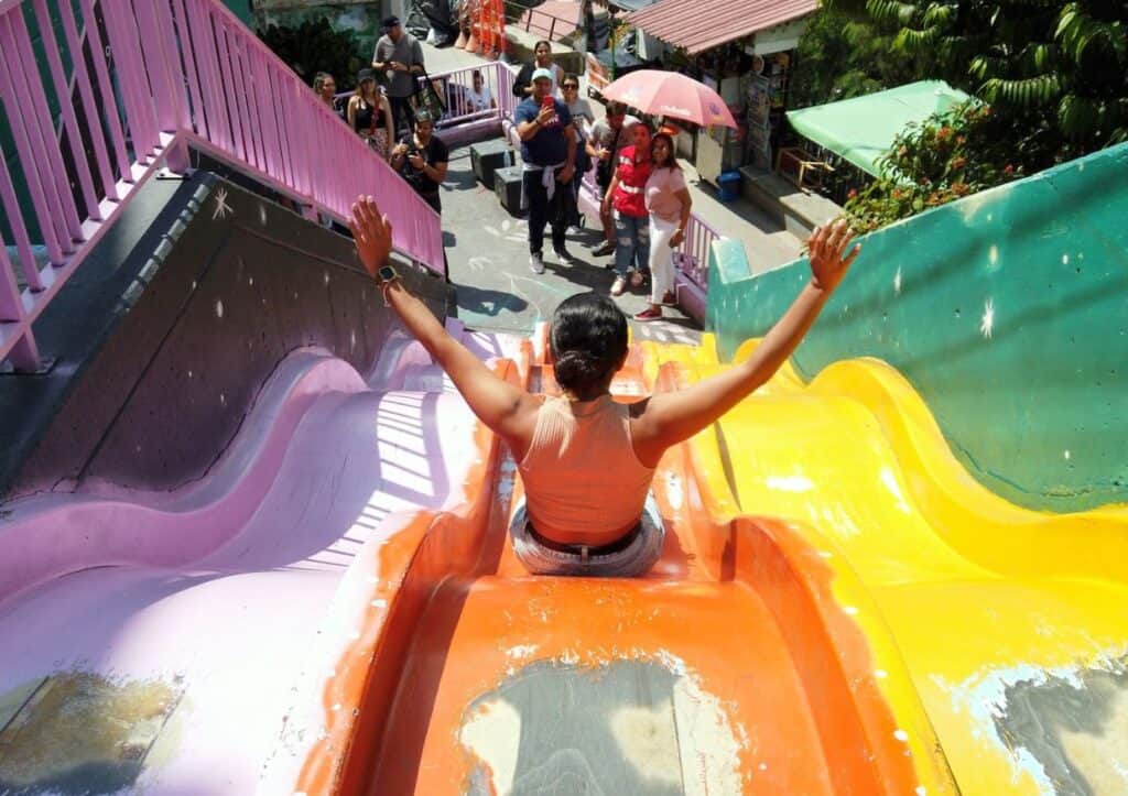 Looking for fun things to do in Medellín? Ride down a colorful water slide with this woman!