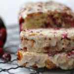 A slice of cranberry bread on a cooling rack.