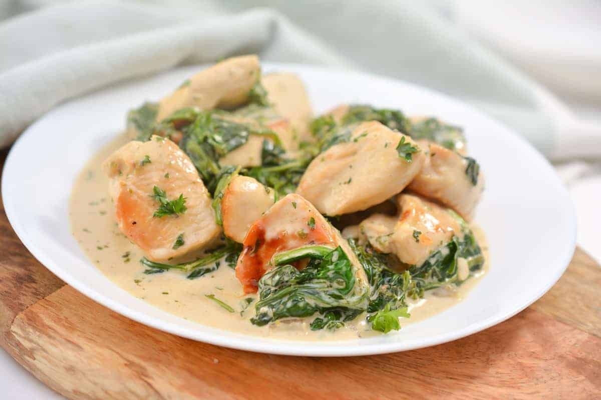 A skillet filled with chicken and spinach.