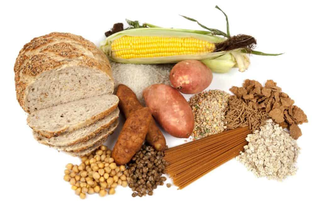 A variety of foods including bread, corn, and pasta, highlighting the difference between net carbs and total carbs.