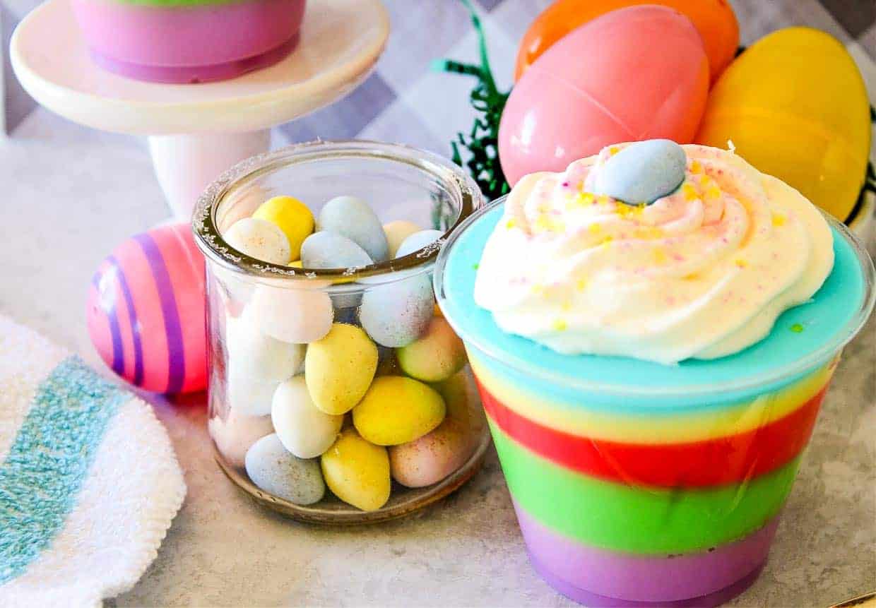 A colorful easter dessert in a cup with eggs and candy.