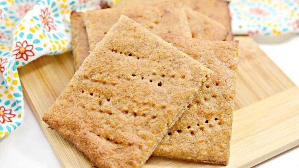 Graham crackers on a wooden cutting board.