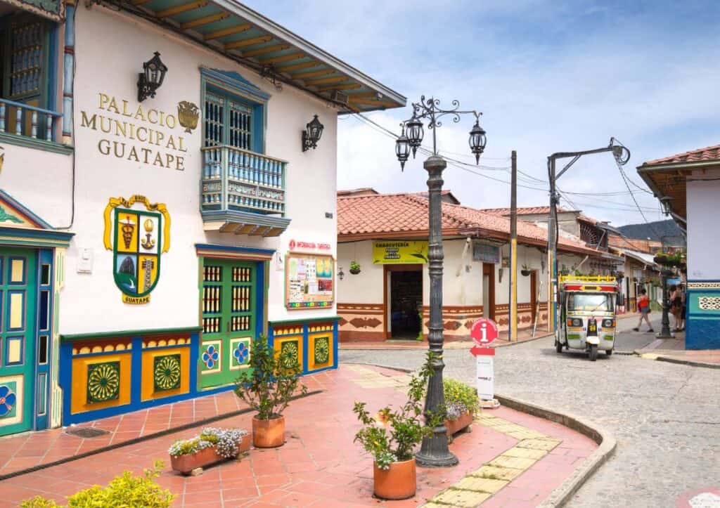 Explore a vibrant street in Colombia lined with colorful painted buildings, perfect for those looking for things to do in Medellín.