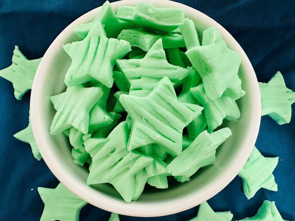 A bowl full of green star shaped mints.