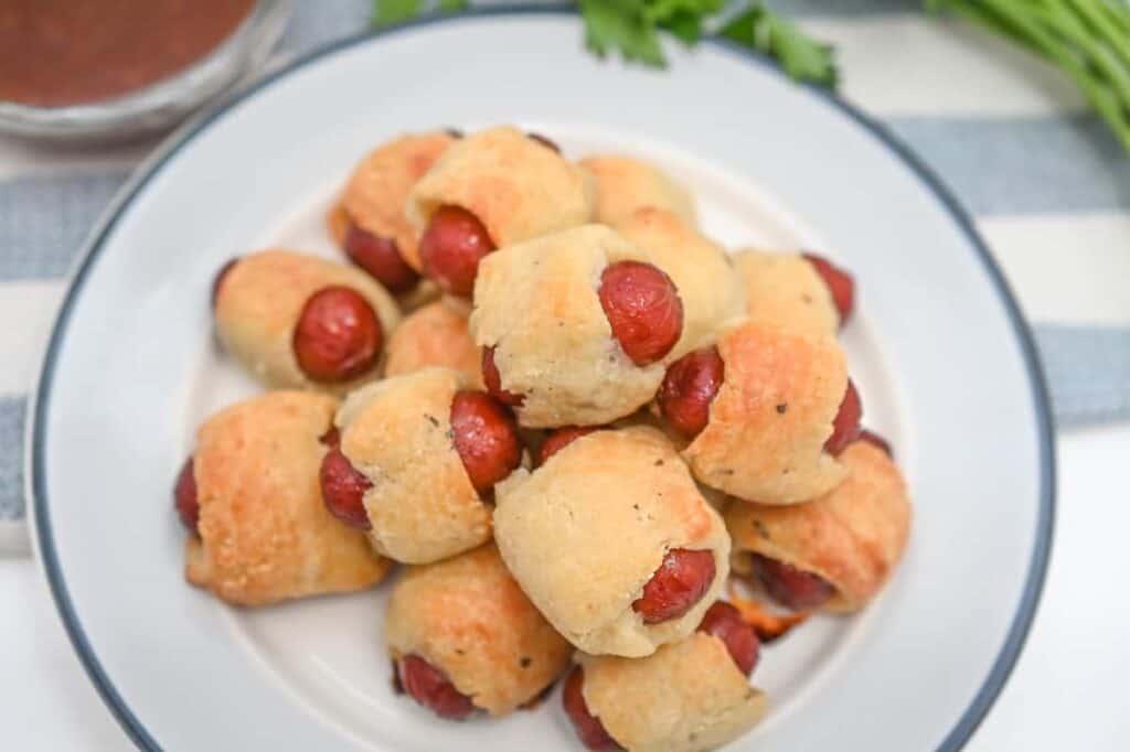 Hot dog buns on a plate with ketchup.