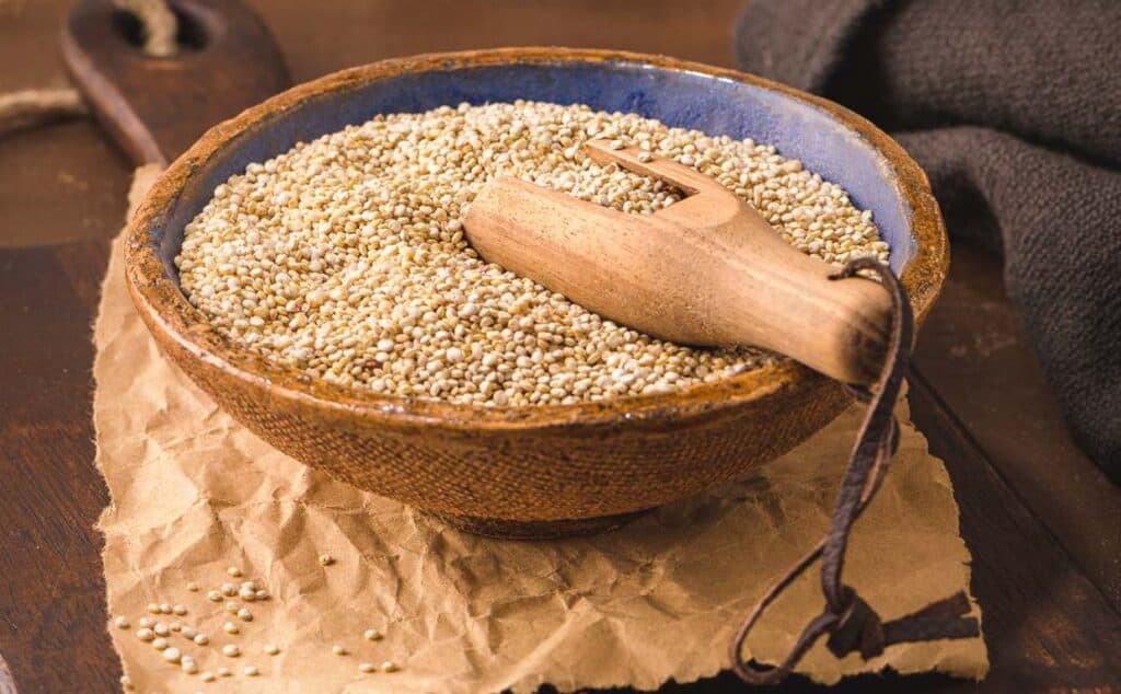 Sesame seeds and quinoa in a bowl on a wooden table.