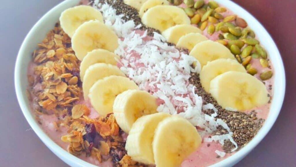 Image shows A smoothie bowl filled with bananas, granola and chia seeds.