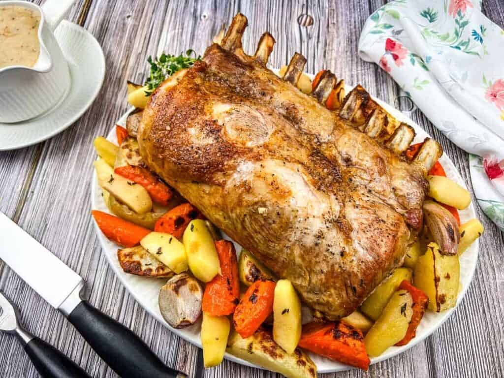A plate of Pork Roast with Apples on a table.