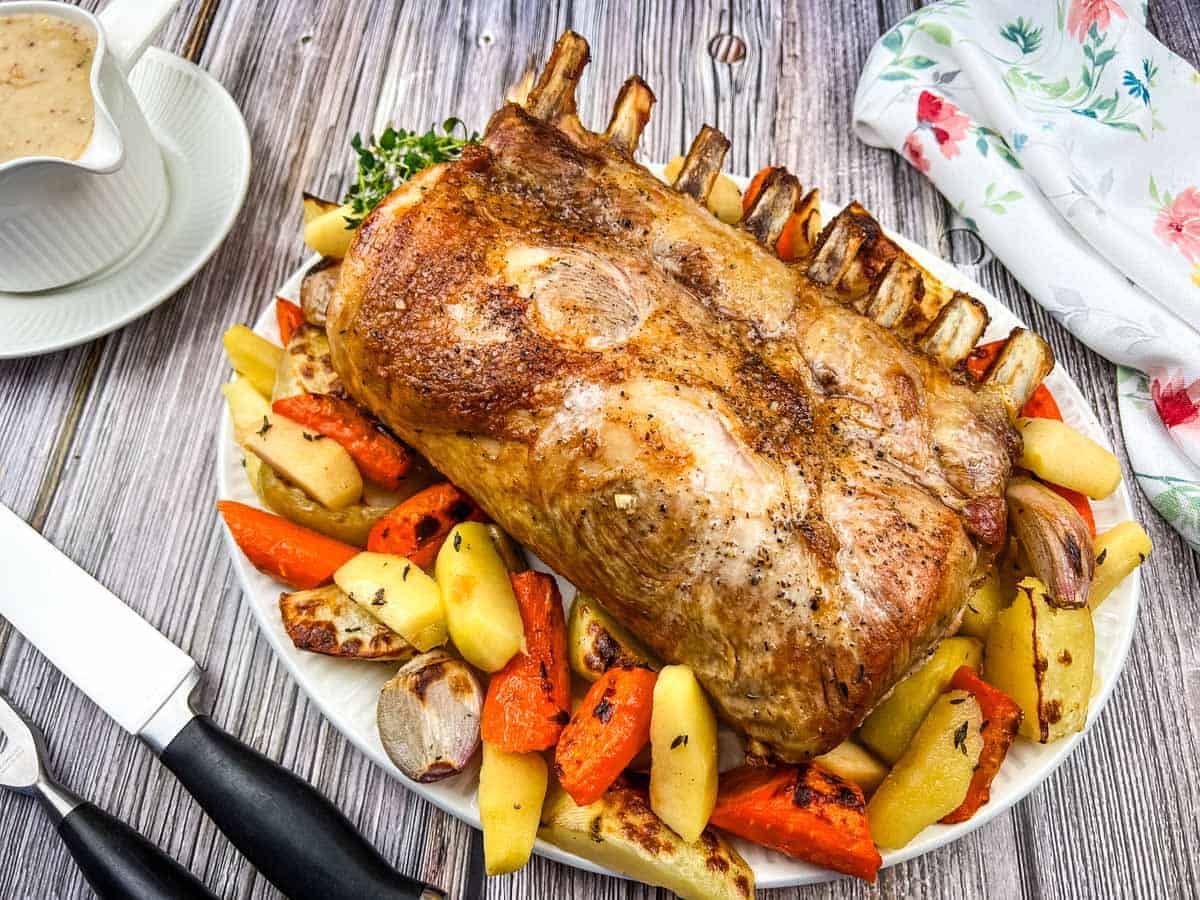 A plate of Pork Roast with Apples on a table.