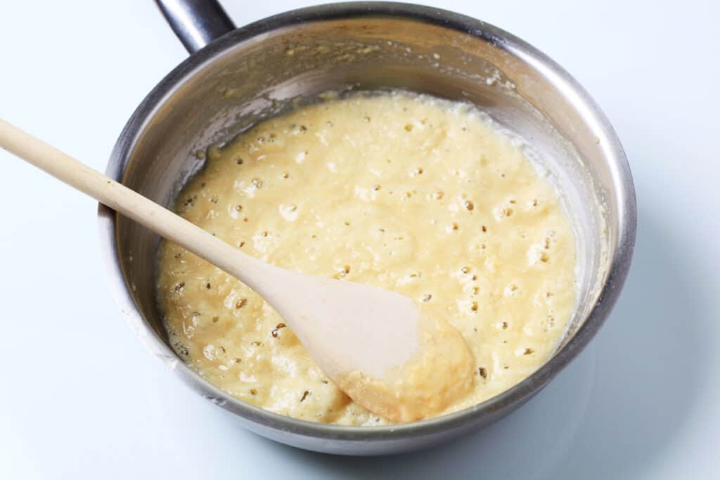 Make a roux in a metal pan with butter, flour and a wooden spoon.