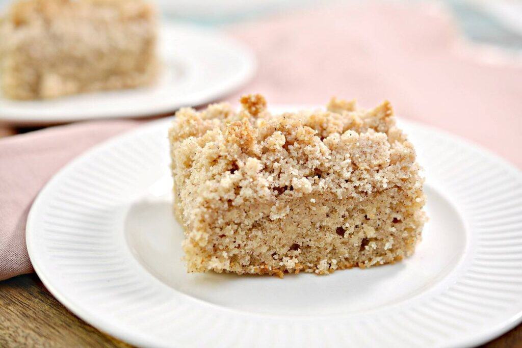 A piece of crumb coffee cake on a plate.