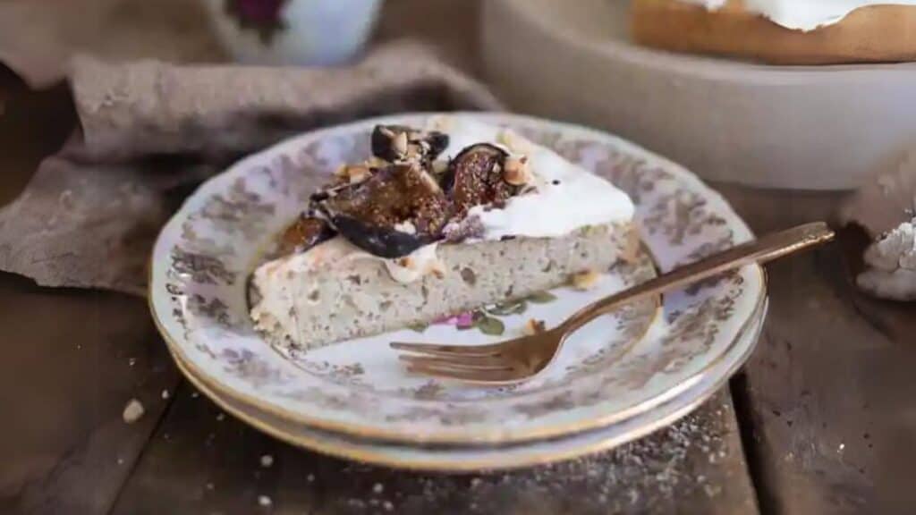 A decadent slice of fig cake on a plate with a fork, perfect for romantic Valentine's desserts.