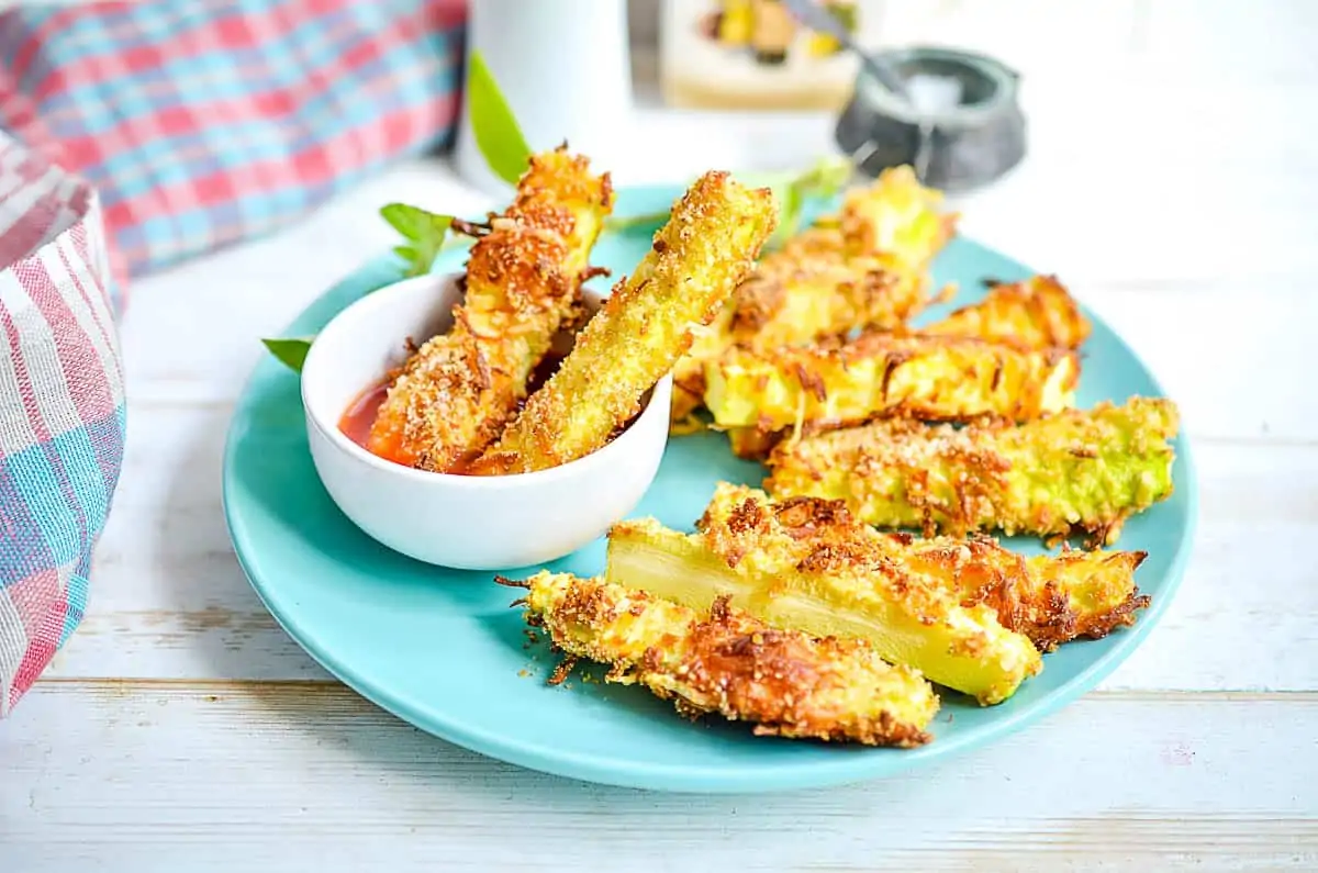 Zucchini fries on a plate with dipping sauce.