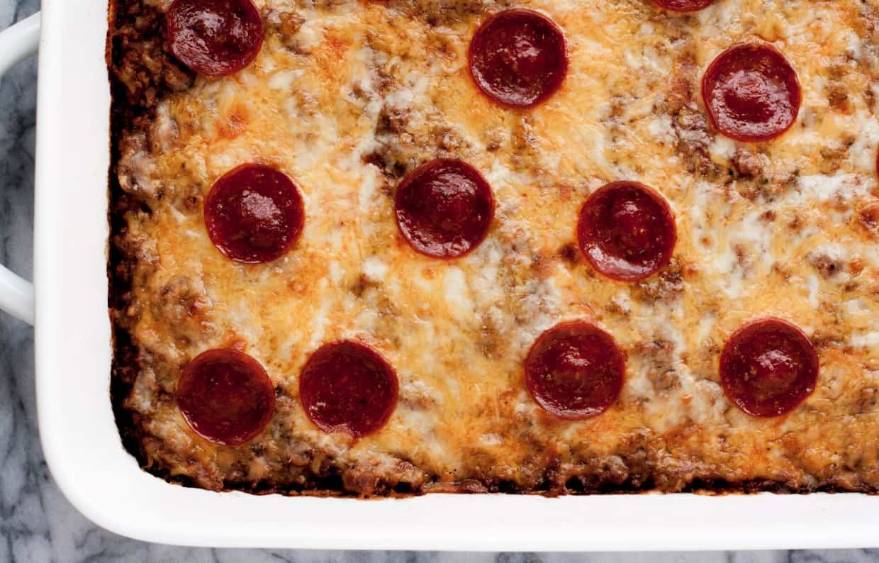 A casserole dish with pepperoni and cheese on top.